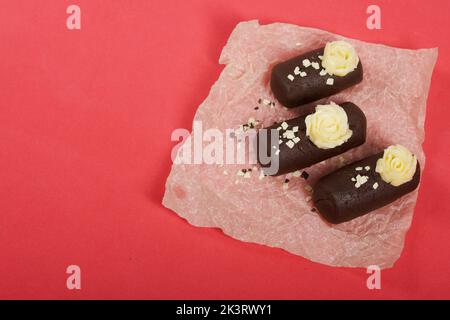 Tortenkartoffel. Dekoriert mit Buttercreme. Auf einem rosa Hintergrund. Nahaufnahme. Stockfoto