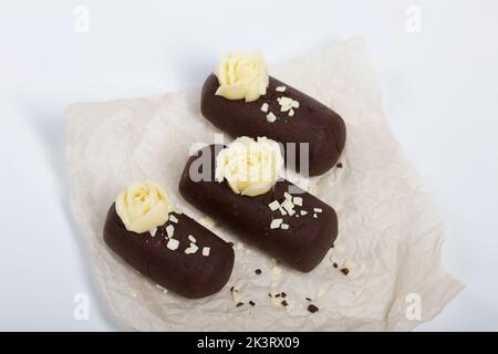 Tortenkartoffel. Dekoriert mit Buttercreme. Auf weißem Hintergrund. Nahaufnahme. Stockfoto