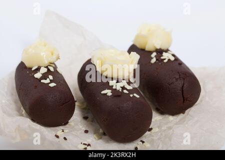 Tortenkartoffel. Dekoriert mit Buttercreme. Auf weißem Hintergrund. Nahaufnahme. Stockfoto