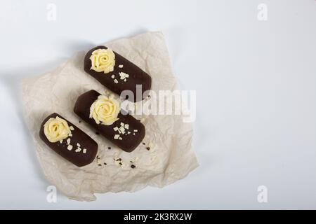 Tortenkartoffel. Dekoriert mit Buttercreme. Auf weißem Hintergrund. Nahaufnahme. Stockfoto