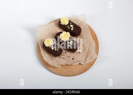 Tortenkartoffel. Dekoriert mit Buttercreme. Auf weißem Hintergrund. Nahaufnahme. Stockfoto