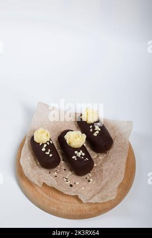 Tortenkartoffel. Dekoriert mit Buttercreme. Auf weißem Hintergrund. Nahaufnahme. Stockfoto