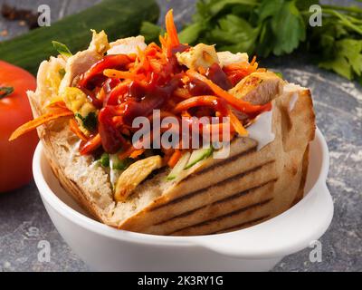 Leckere Shawarma mit Huhn in einer Grube mit Karotten und Ketchup. Nahaufnahme Stockfoto