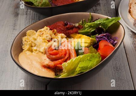 Schmackhafter Poke mit Lachs, Avocado, Omelette und Gemüse Stockfoto