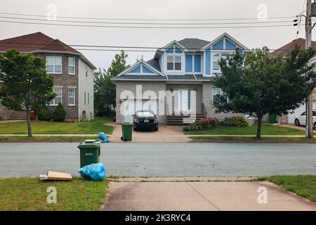 Mülltrennung - Recycle Blue Bags, Wellpappenkartons und Green Organic Waste Cart, die draußen gehalten werden. HALIFAX, NOVA SCOTIA, KANADA - JULI 2022 Stockfoto