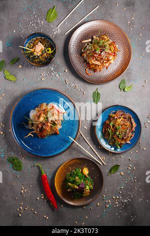Leckere asiatische Gerichte: Verschiedene Nudeln, Cellophan, Suppe mit Lachs. Draufsicht Stockfoto