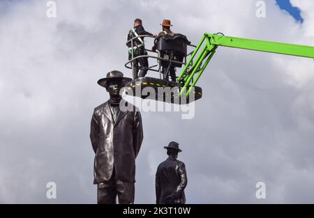 London, Großbritannien. 28. September 2022. Der Künstler Samson Kambalu steht auf einer mobilen, höhenverstellbaren Arbeitsbühne neben seiner Skulptur 'Antelope', die als neuestes Kunstwerk für den vierten Sockel auf dem Trafalgar Square enthüllt wurde. Das Kunstwerk zeigt Statuen des panafrikanischen Predigers und Baptistenpredigers John Chilembwe und des europäischen Missionars John Chorley. Kredit: Vuk Valcic/Alamy Live Nachrichten Stockfoto