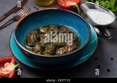 Leckere Dolma mit Fleisch in Traubenblatt und Kefir-Sauce Stockfoto