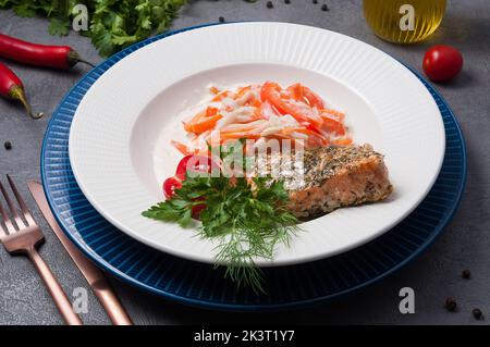 Schmackhafter Lachs mit Gewürzen, gebacken mit Gemüse in Rahm Stockfoto
