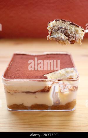 Nahaufnahme eines Löffels, der das köstliche Tiramisu oder toskanisches Kleingebäus ausschaufelt Stockfoto