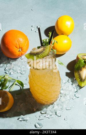 Leckerer Fruchtcocktail mit Eiscreme, dekoriert mit Orange, Zitrone und Kiwi Stockfoto