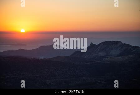 Sonnenuntergang über der Insel Naxos, Kykladen Ziel Griechenland. Die Natur beruhigt das Konzept. Sonnenuntergang, hinter Hügeln Silhouette, Farben orange und Gold gelb die Stockfoto