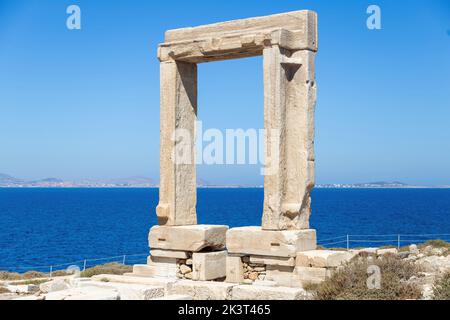 Insel Naxos, Apollotempel, Kykladen Griechenland. Portara, Marmortor, sonniger Tag, ruhiges Meer, blauer Himmel im Hintergrund. Stockfoto