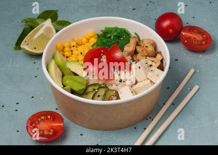 Schmackhafter vegetarischer Poke mit Avocado, Pilzen, Mais, chuka, Tofu-Käse, Gurken und Kirschtomaten Stockfoto