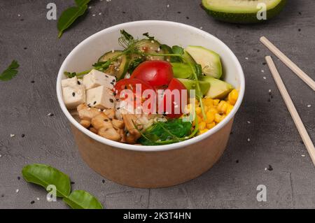 Schmackhafter vegetarischer Poke mit Avocado, Pilzen, Mais, chuka, Tofu-Käse, Gurken und Kirschtomaten Stockfoto