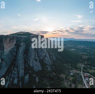 Meteora Griechenland Kloster der Heiligen Dreifaltigkeit bei Sonnenuntergang. Farbenprächtiger Himmel mit Wolken über Gebäuden auf Felsen. Reiseziel Europa Stockfoto