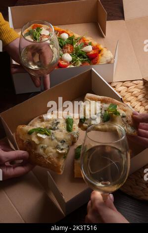 Die Menschen essen leckere italienische Pizza mit Weißwein. Konzept: Lieferung von Lebensmitteln Stockfoto
