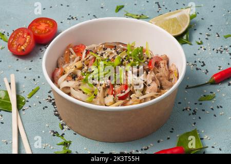 Leckeres udon mit Schweinefleisch und Gemüse in handwerklichen Gerichten Stockfoto