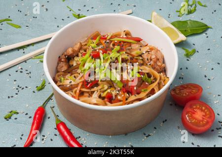 Leckere Weizennudeln mit Huhn und Gemüse in einem handwerklichen Gericht Stockfoto