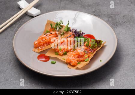 Leckere knusprige Chips mit leicht gesalzenem Lachs und heißer Sauce Stockfoto