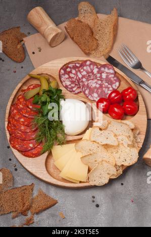 Holzplatte mit verschiedenen Wurst- und Käsesorten mit Croutons Stockfoto