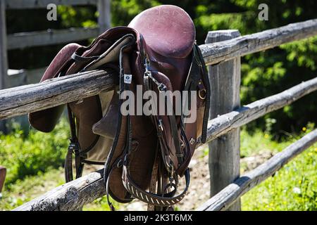 Nahaufnahme eines Sattels auf einem Holzzaun Stockfoto