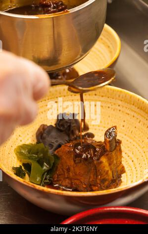 Leckeres Schweinefleisch auf Rippchen mit Holzpilzen und Sauce Stockfoto