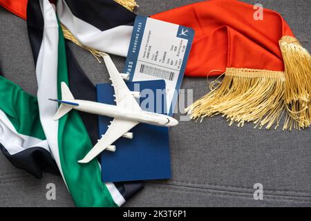 Nationale VAE, US-Flaggen, Spielzeugflugzeug und Pässe auf grauem Hintergrund Stockfoto