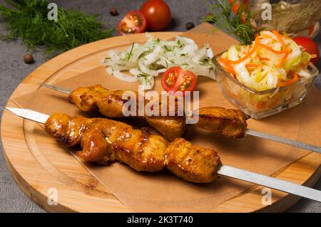 Leckerer Hähnchen-Shish-Kebab mit eingelegten Zwiebeln und Kohlsalat Stockfoto