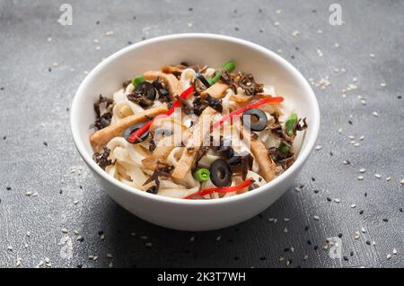 Leckeres udon mit Huhn, Gemüse und Pilzen. japanische Küche Stockfoto