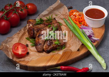 Schmackhafter Schweinebab auf dem Knochen mit Karotten und Tomatensauce Stockfoto