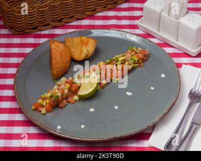 Leckere Lachstartare mit Avocado und einer Scheibe Limette im Restaurant Stockfoto