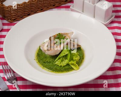 Leckeres Hechtbarschfilet auf einem Spinatkissen in einem Restaurant Stockfoto