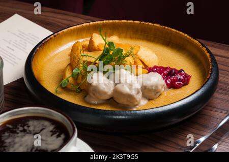Leckere Kartoffelscheiben mit Fleischbällchen in Bechamelsauce und Beerensauce Stockfoto