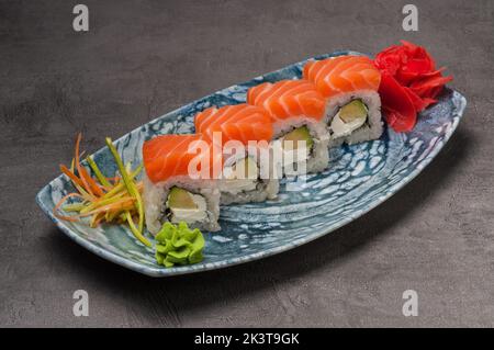 Leckere Sushi-Brötchen mit Lachs, Avocado und Frischkäse Stockfoto