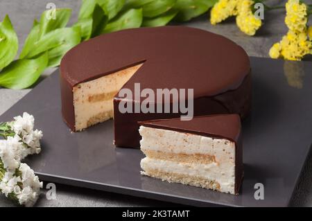 Zarter Souffle kombiniert mit duftendem Mandelkuchen, verziert mit einer natürlichen Milchschokoladenglasur Stockfoto