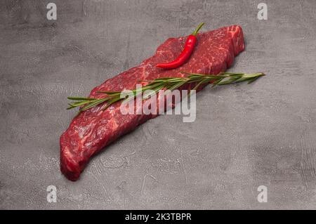 Saftiges marmoriertes Rindersteak, garniert mit Rosmarin und Pfeffer Stockfoto