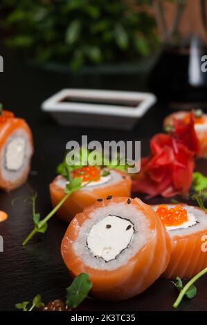 Leckere Sushi-Brötchen mit Lachs und Frischkäse Stockfoto