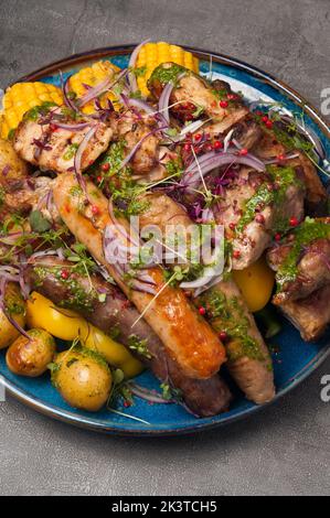 Leckere Fleischsorten, Würstchen und gegrilltes Gemüse im Restaurant Stockfoto