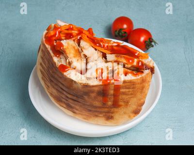 Leckere Pita mit Huhn und Gemüse beträufelt mit Ketchup Stockfoto