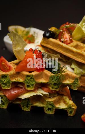 Leckere belgische Waffeln auf Spinatteig mit Lachs, Käse und Kaviar. Konzept: Frühstück Stockfoto