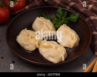 Leckeres traditionelles usbekisches Gericht mit gehackter Fleisch- und Gemüsefüllung. manty oder Manti Stockfoto