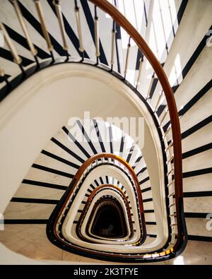 Eine vertikale Aufnahme einer weißen Wendeltreppe. Stockfoto