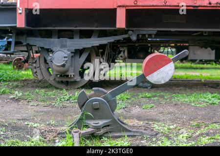 Foto eines alten Gleisschalthebels. Waggonrad im Hintergrund. Stockfoto