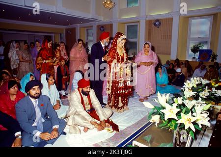 Sikh Hochzeit - Mutter Und Vater Versengende Braut Trägt Romalla Tuch Central Gurdwara Shepherds Bush London England Stockfoto