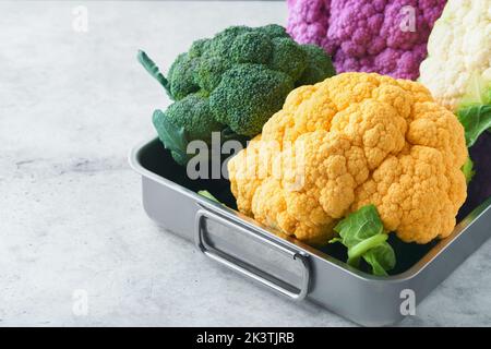 Colorfu-Blumenkohl. Verschiedene Arten von Blumenkohl auf grauem Beton Hintergrund. Violette, gelbe, weiße und grüne Farbkabbage. Brokkoli und Romanesco. Stockfoto