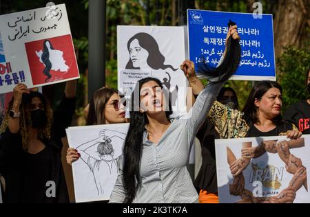 Seoul, Südkorea. 28. September 2022. Eine iranische Protestantin singt Slogans, während sie ihre geschnittenen Haare während einer Kundgebung gegen den Tod des Iraners Mahsa Amini vor der Botschaft der Islamischen Republik Iran in Seoul hält. Iranische Demonstranten veranstalteten eine Kundgebung, in der sie die starke Niederschlagung der lokalen Proteste durch die iranische Regierung kritisierten, die den plötzlichen Tod von Mahsa Amini mit sich brachte, der in Teheran verhaftet worden war, weil er angeblich das strenge Gesetz verletzt hatte, wonach Frauen Anfang des Monats ihre Haare mit einem Hijab oder Kopftuch bedecken sollten. Kredit: SOPA Images Limited/Alamy Live Nachrichten Stockfoto