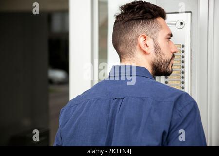 Der Anlieferer stand in der Tür, während er darauf wartete, dass er anwesend war Stockfoto