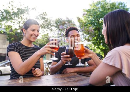 Verschiedene Freunde, die zur Happy Hour Bier trinken Stockfoto