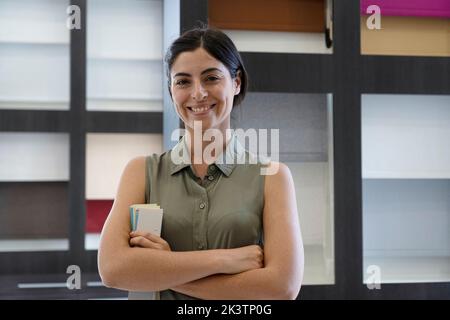 Mid-Shot-Porträt einer erfolgreichen lateinamerikanischen Dekorationskauffrau, die in ihrem Studio posiert Stockfoto